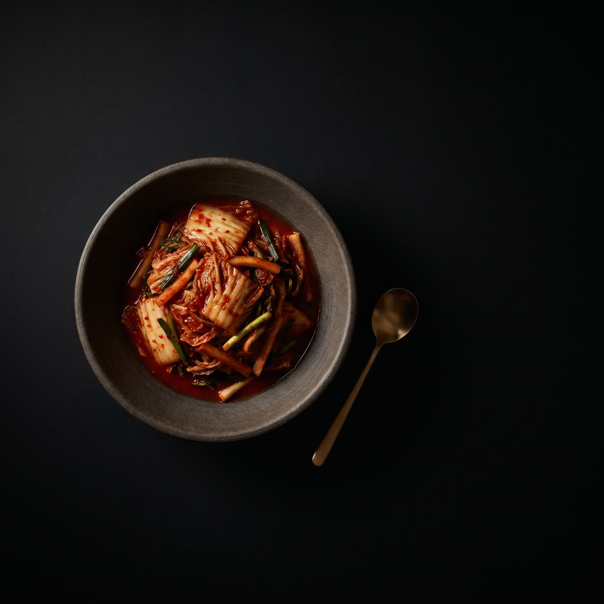 A single bowl of Korean banchan on dark ceramic